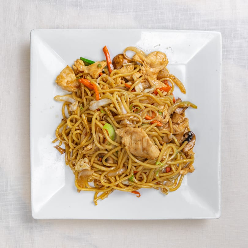 Flaming Wok's chicken lo mein, with noodles, chicken, carrots, cabbage, and mushrooms on a white plate.
